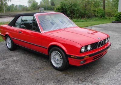Red 1993 BMW 325i convertible E30 outside from the front.